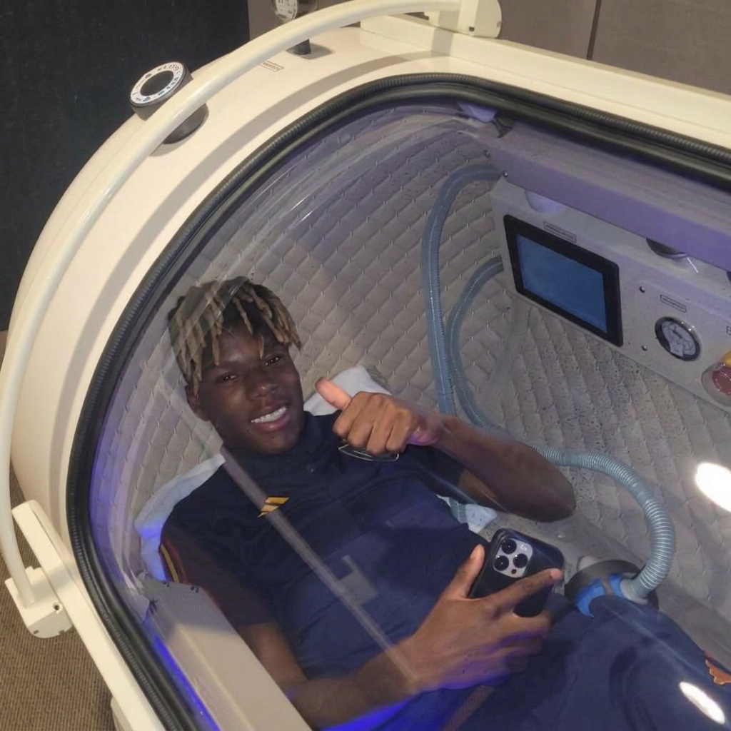 Athlete inside a Lifemax chamber giving a thumbs-up during a recovery session.